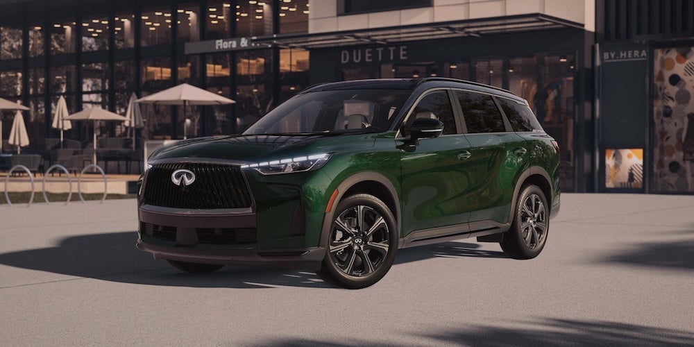 A dark green 2027 INFINITI QX60 SUV parked outside a cafe