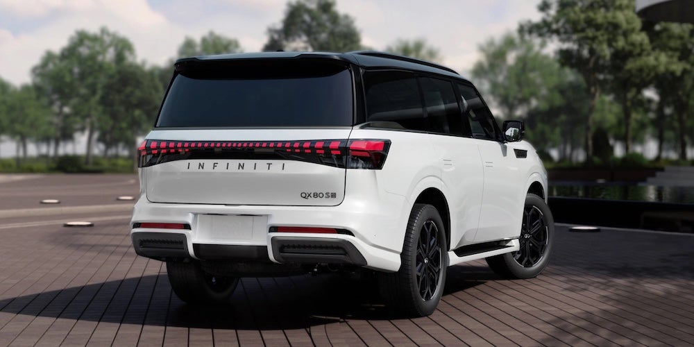 A white 2027 INFINITI QX80 SUV parked on a patio